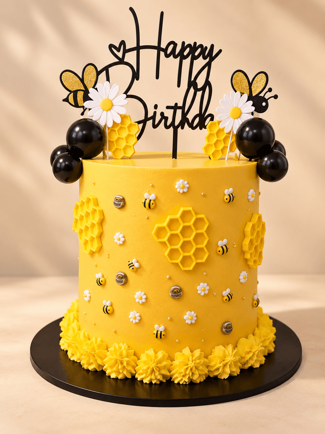 Yellow bee-themed birthday cake with honeycomb details and a Happy Birthday topper