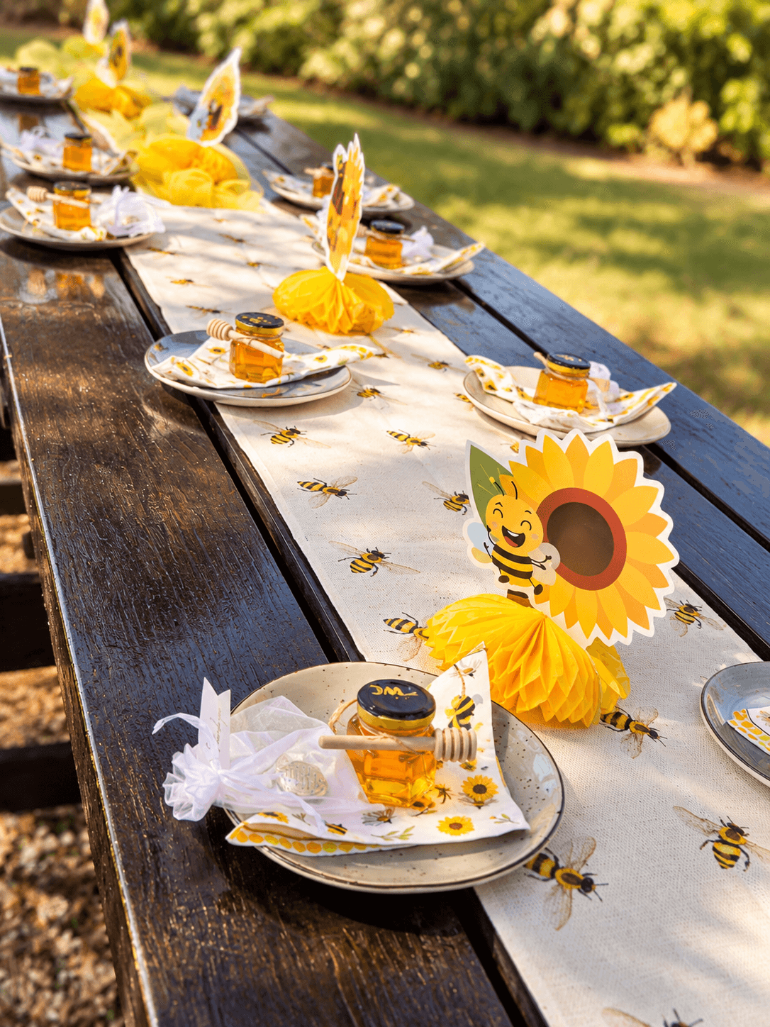 Bee-themed garden party table with honey jar favours and sunflower centrepieces