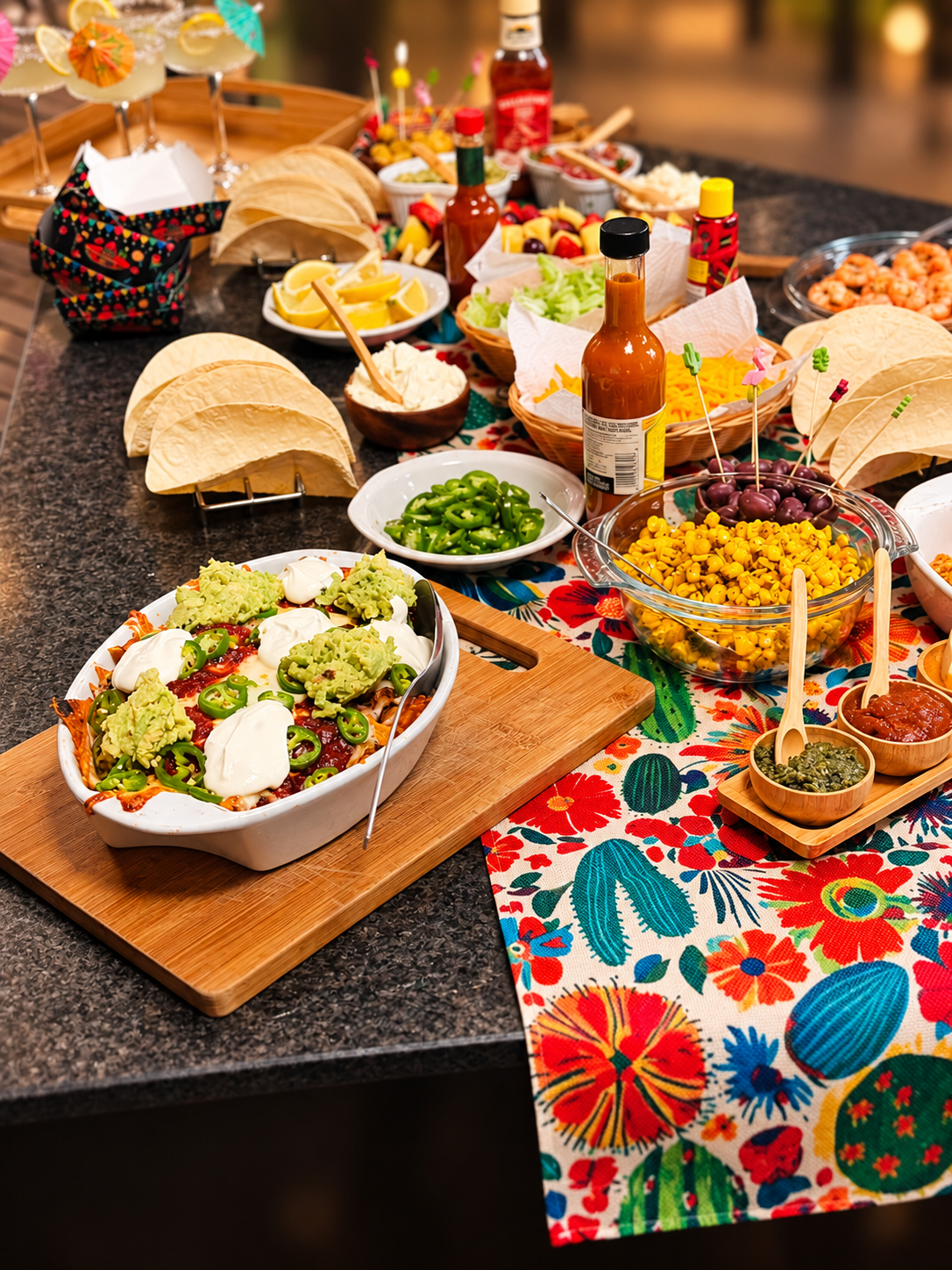 Mexican fiesta taco bar with nachos, guacamole, jalapeños, corn and a colourful cactus runner